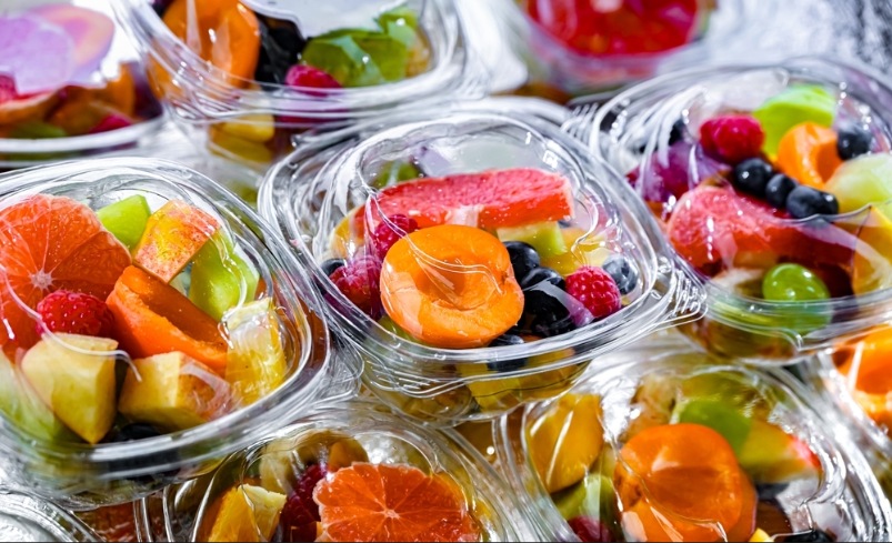 Plastic boxes with pre-packaged fruit salads, put up for sale in a commercial refrigerator