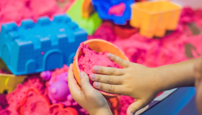 Boy playing with kinetic sand in preschool. The development of fine motor concept. Creativity Game concept