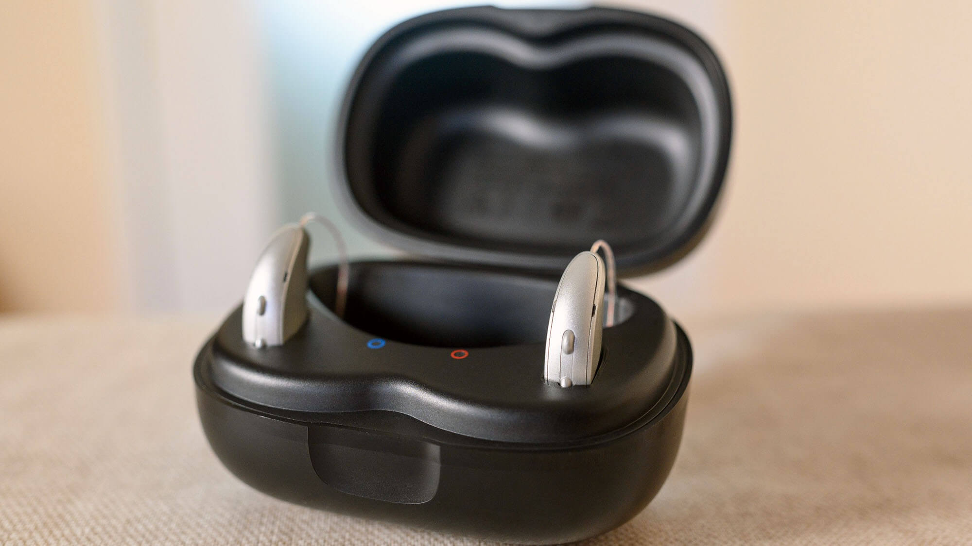 Hearing aid devices charging in black case on table
