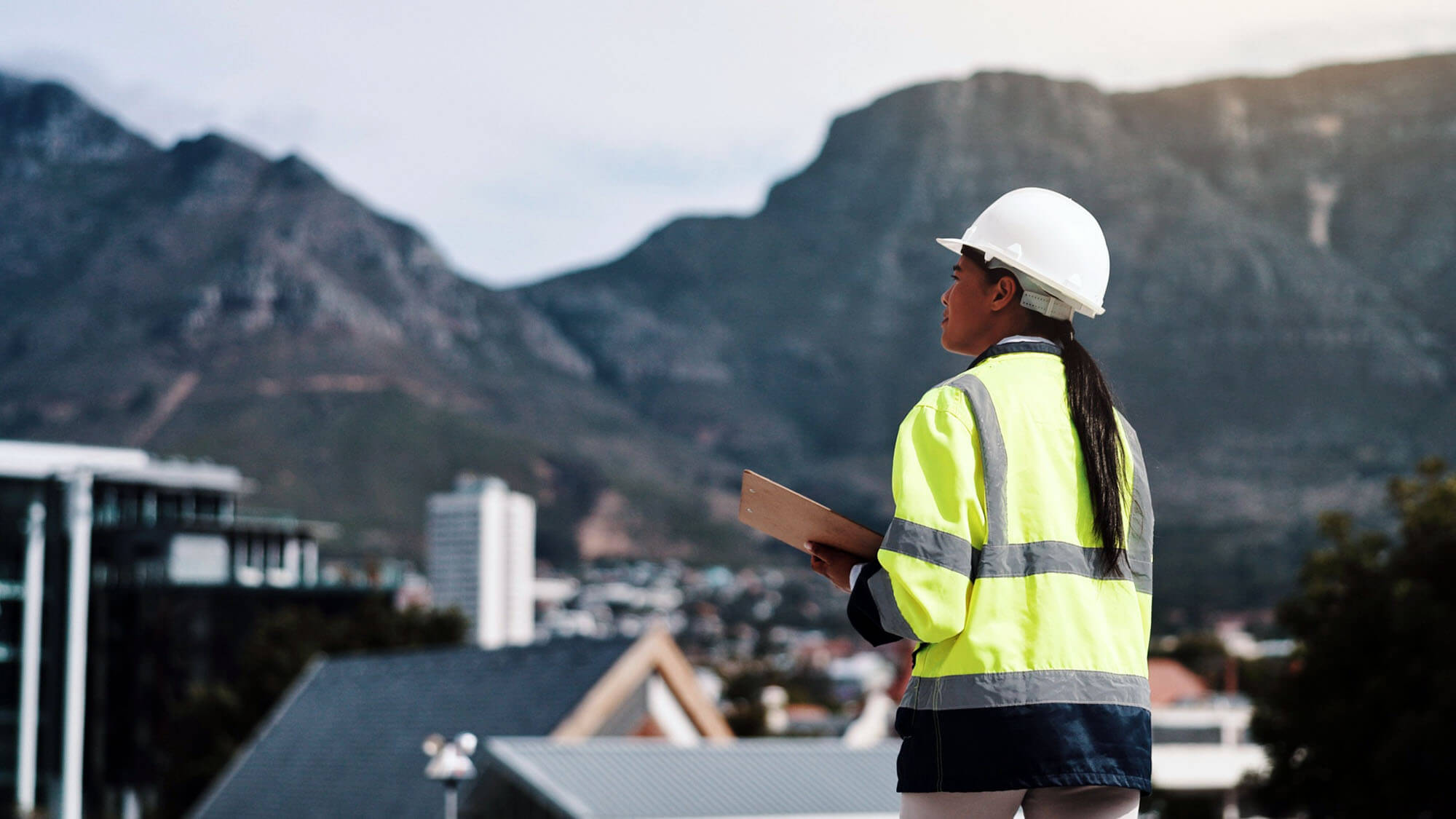 Engineer, woman and clipboard with building inspection for location surveying, safety compliance or planning. Construction, contractor back or checklist for risk management or quality control on roof. 